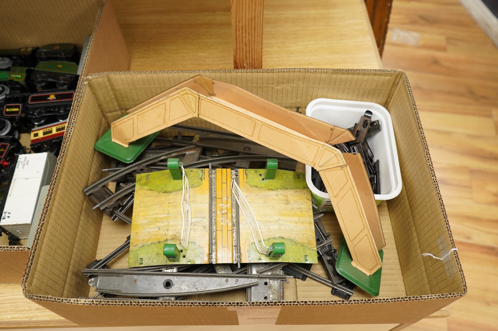 A collection of 0 gauge Hornby tinplate clockwork railway, including four BR locomotives, 17 freight wagons and four wheel coaches, together with a station building, signal cabin, and Goods depot (missing base), plus a f